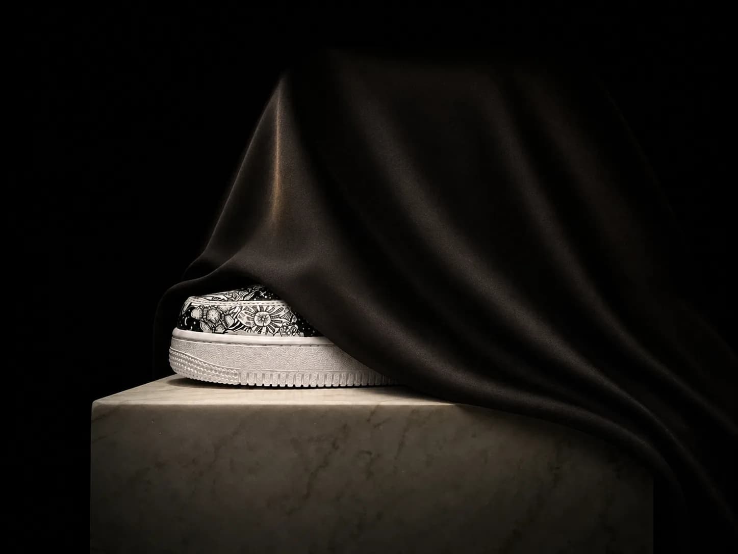 A finished pair on a marble plinth, half-hidden under a black satin veil