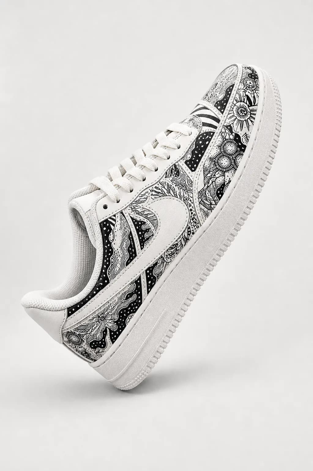 A monochrome hand-painted sneaker photographed clean against a pale studio wall